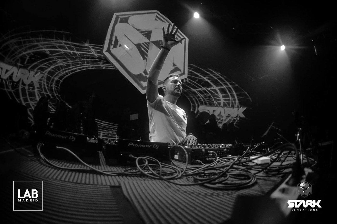 Fran Arés en la cabina durante una sesión de club, en blanco y negro · PLAYNOW