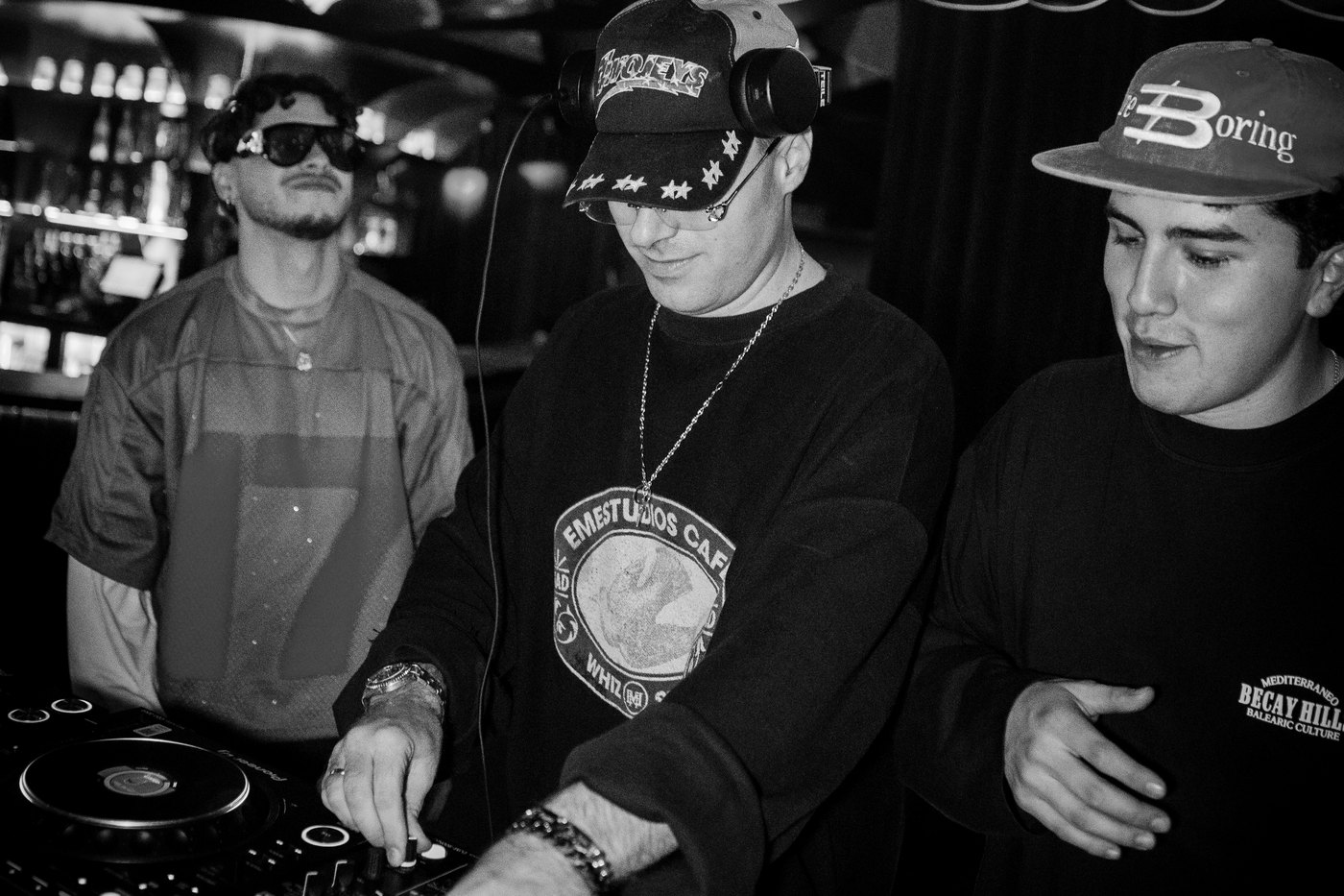 LAX, DJ de afro house e indie dance, pinchando en cabina, fotografía en blanco y negro · PLAYNOW